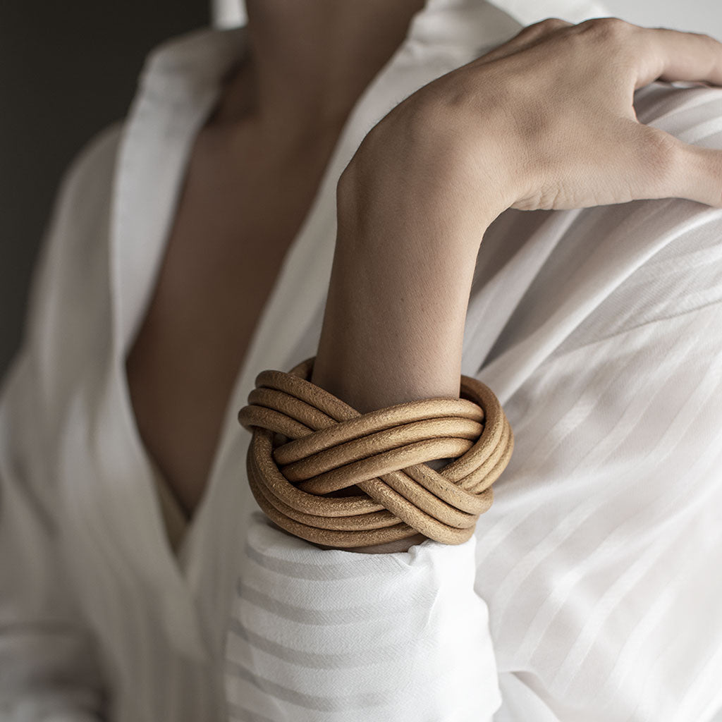 Bracciale pelle Tulsi Nodomoro - Intreccio realizzato a mano - Colore pelle oro - Indossato donna dettaglio